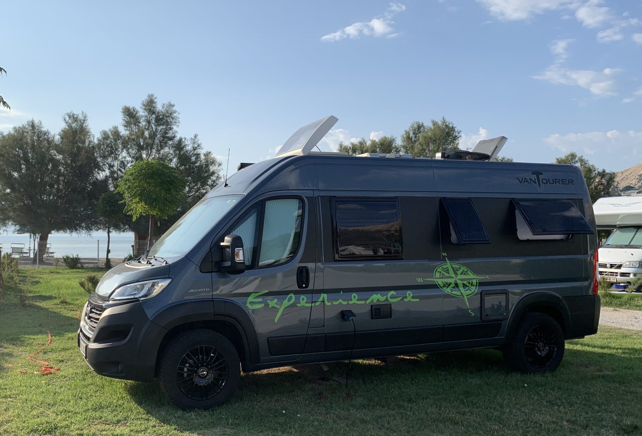 Wohnmobil am Campingplatz vor dem Strand.